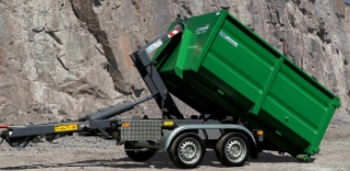Zelený kontejner na přívěsu s hydraulickým naklápěním.