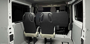 Interiér dodávky s třemi sedadly.