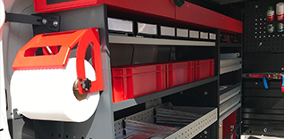 Organizovaný systém úložného prostoru v dodávce s držákem na papírové ručníky.