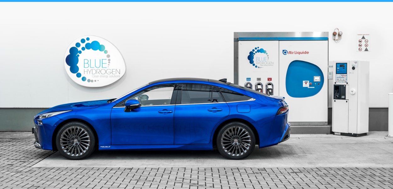 Modrý Toyota Mirai zaparkovaný u vodíkové čerpací stanice
